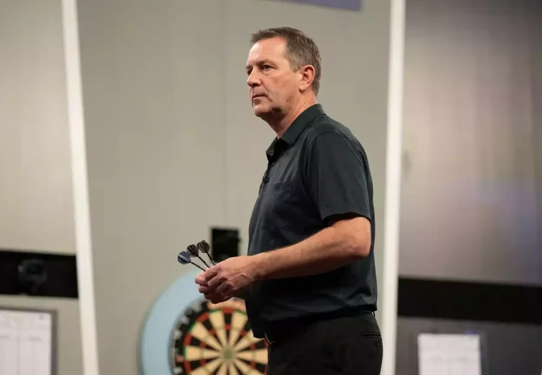 Männlicher Darts-Profi während eines PDC-Major-Turniers mit fokussierter Wurfhaltung
