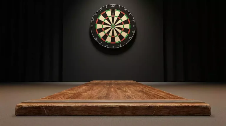 Detailaufnahme der Oche-Linie auf der Bühne mit Dartpfeil in der Mitte des Triple-20-Feldes
